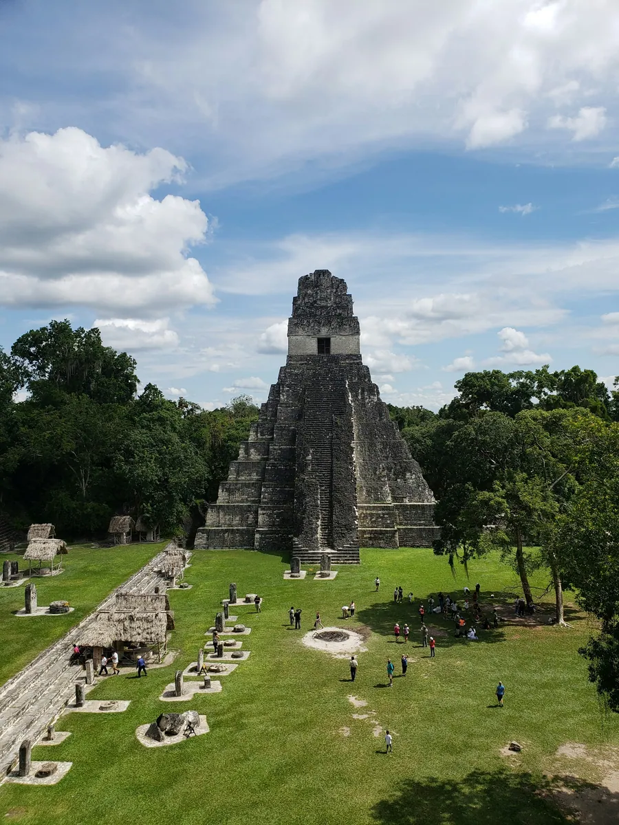 Maya-Stufenpyramide Tempel I in Tikal am Großen Platz, davor Stelen und Besucher, ringsum Regenwald