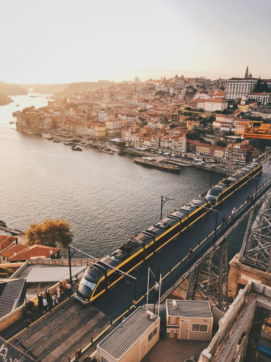 Metrozug auf dem Oberdeck der Brücke Dom Luís I in Porto, darunter der Douro und die Altstadt am Ufer